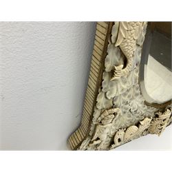 Pair 19th century French Dieppe bone and ivory wall mirrors, the oval bevelled mirror plates within rectangular frames with shaped tops, profusely decorated with ivory leaves, further detailed with carved bone armorial type crest inscribed 'SGOTORVM', putti, fish and mask heads, H81cm W48cm