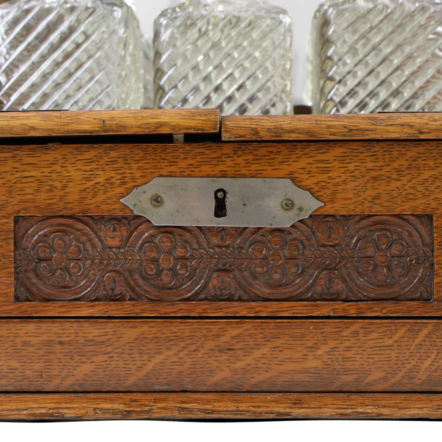 Victorian brass mounted oak tantalus, containing a set of three decanters, fitted with a games compendium to the front, H32cm