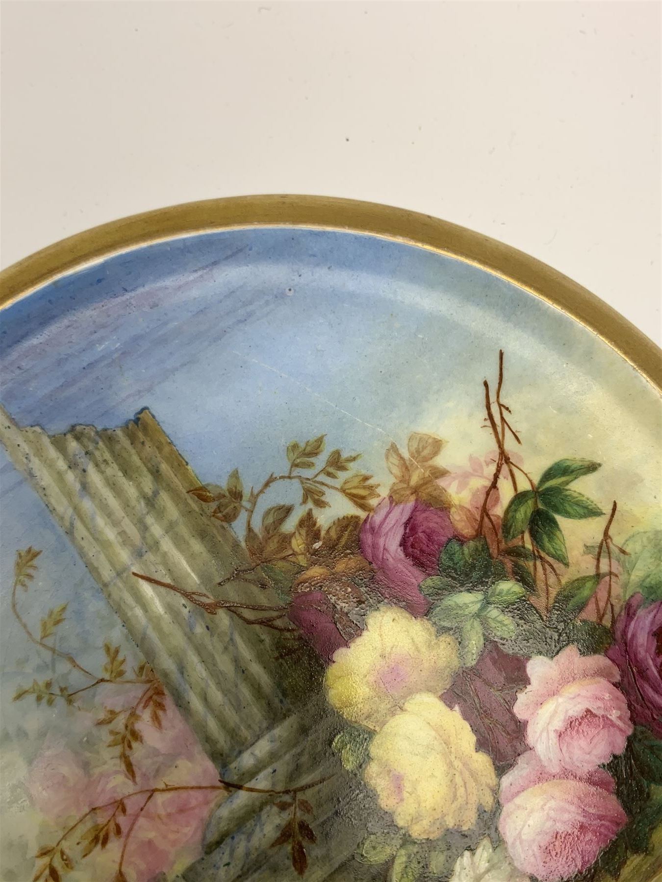 19th century porcelain stand, of circular form, in the Derby style, hand painted with a ruinous column and roses against a landscape background, within a gilt border, D7cm