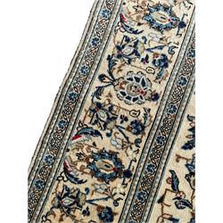 Persian Kashan ivory ground rug, the field decorated with trailing branches with leaves and palmettes, similar scrolling border, within floral pattern guard stripes 
