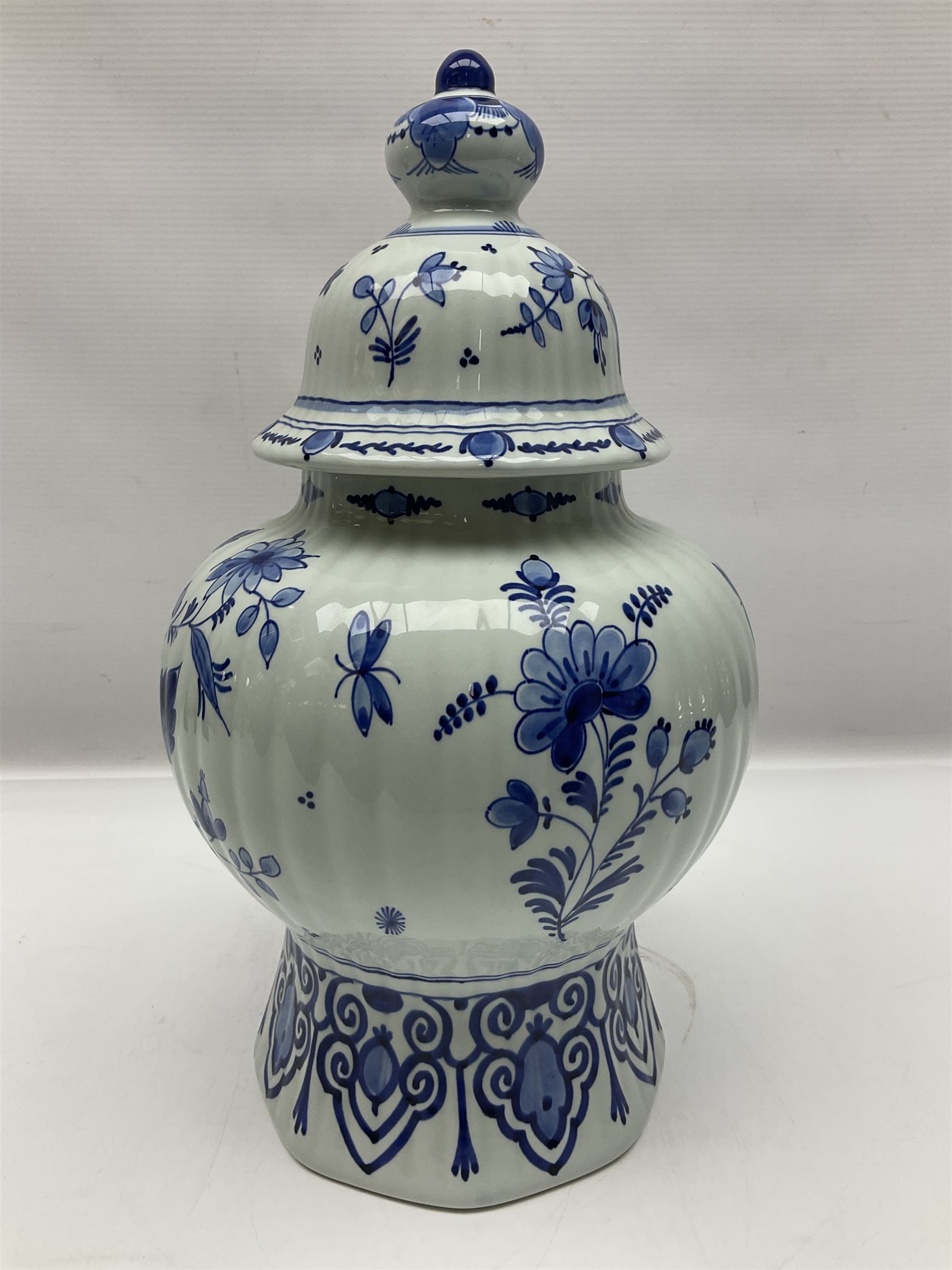 De Porceleyne Fles Delftware blue and white covered jar, of fluted baluster form, with floral and insect decoration, upon an octagonal foot, the octagonal cover with urn shaped finial, H32cm