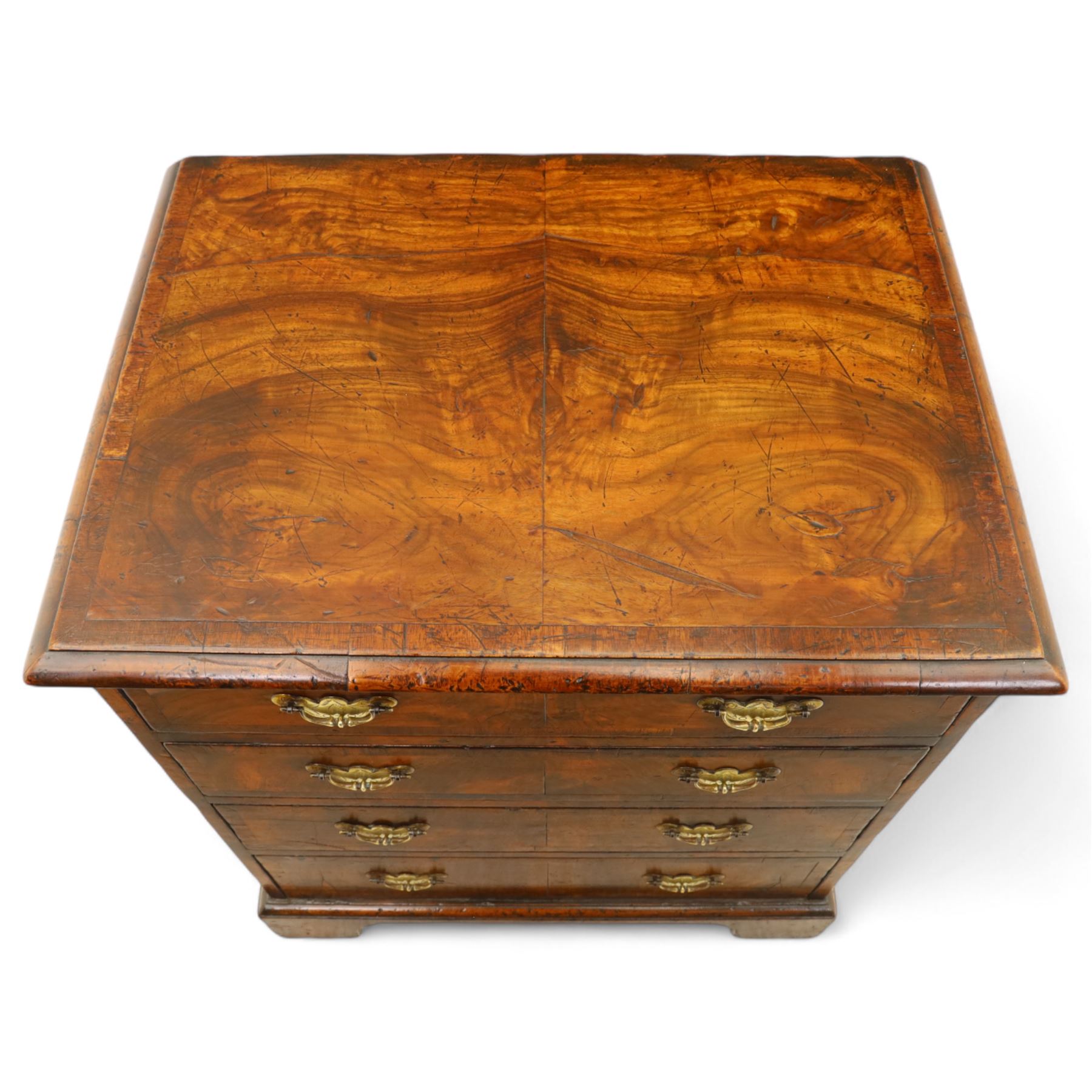 Small 19th century figured walnut chest of drawers, rectangular top with moulded edge over four graduating drawers with brass batwing handles, raised on bracket feet