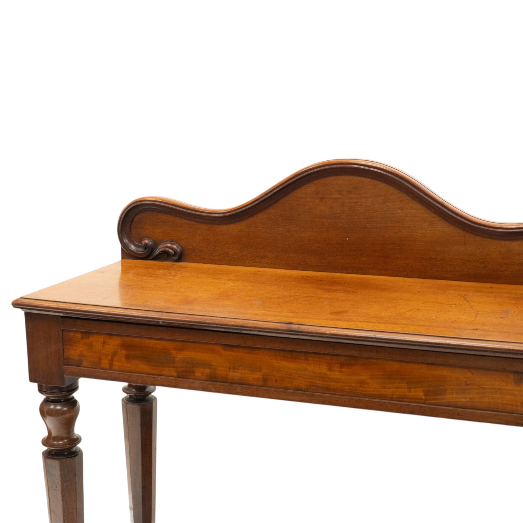 Victorian mahogany side table, raised back with scroll-moulded edge over a rectangular top, raised on turned octagonal supports