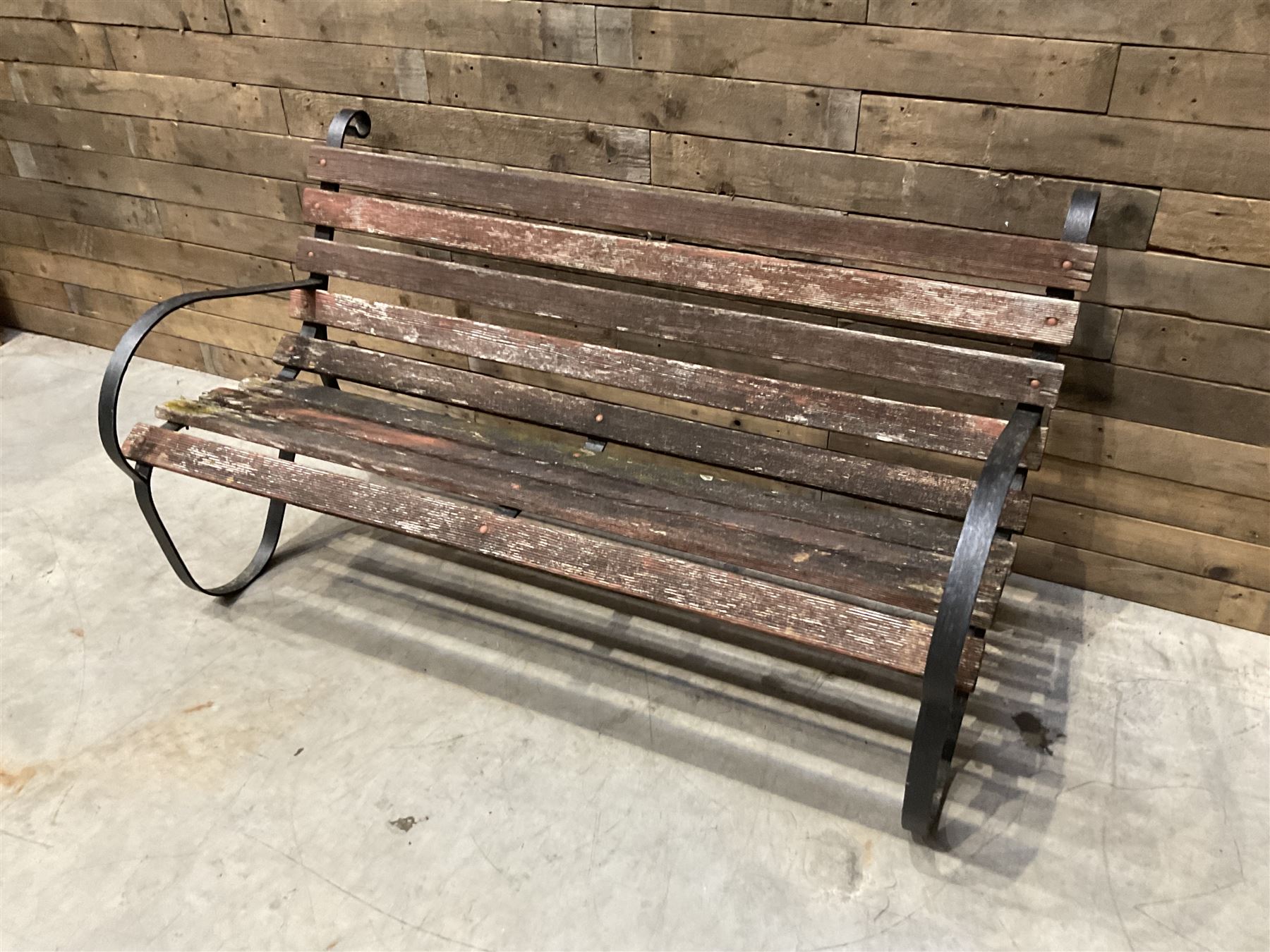Early 20th century black painted wrought iron and wood slatted garden bench
