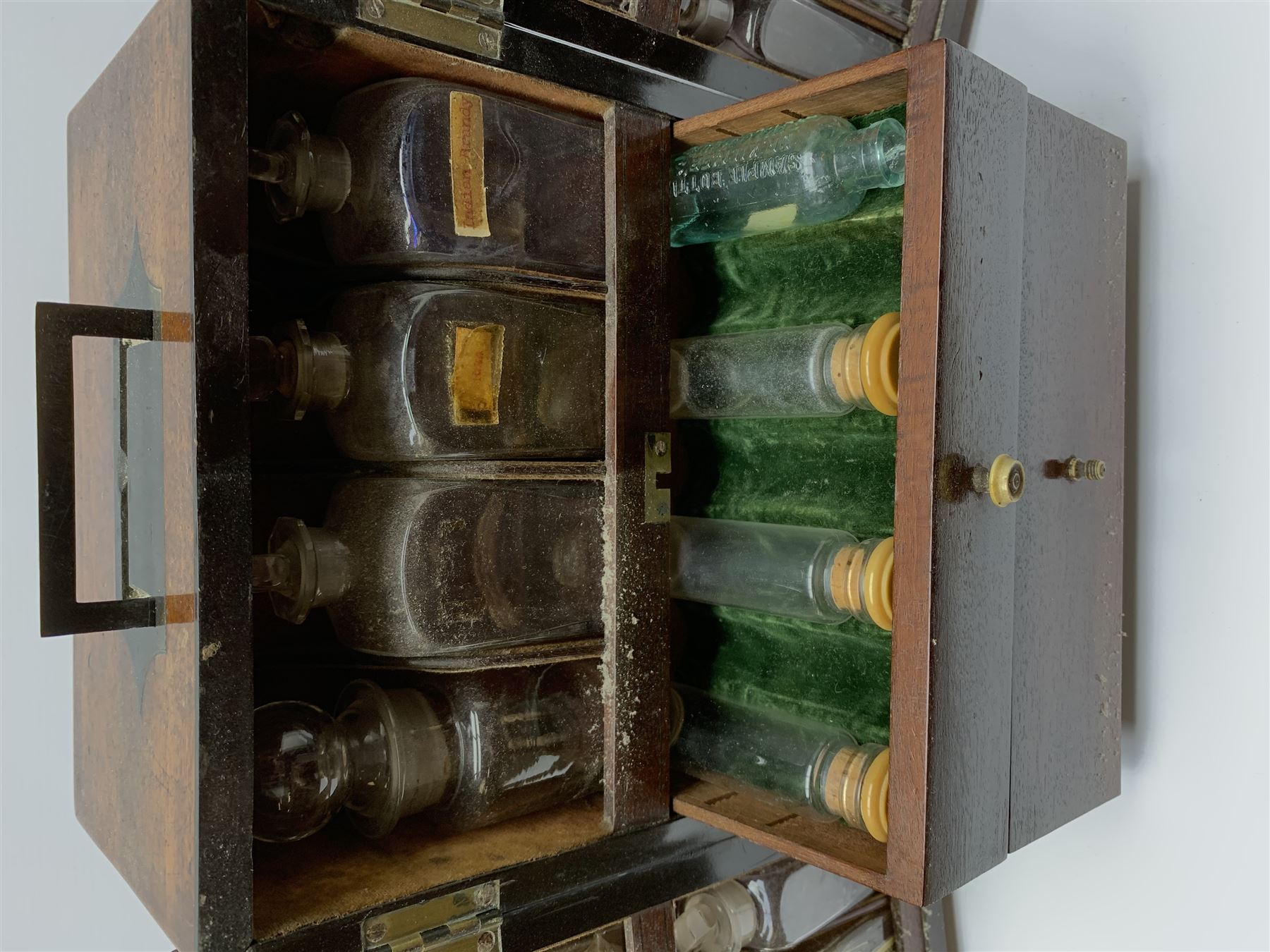 19th century mahogany travelling apothecary cabinet, with recessed brass carry handle to top, and two deep-section hinged doors to the front opening to reveal a fitted interior with clear glass bottles and two drawers, H27cm