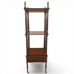 Late Victorian mahogany whatnot, the three tiers supported by turned spindle uprights with turned finials, fitted with a single frieze drawer, raised on turned supports with brass castors
