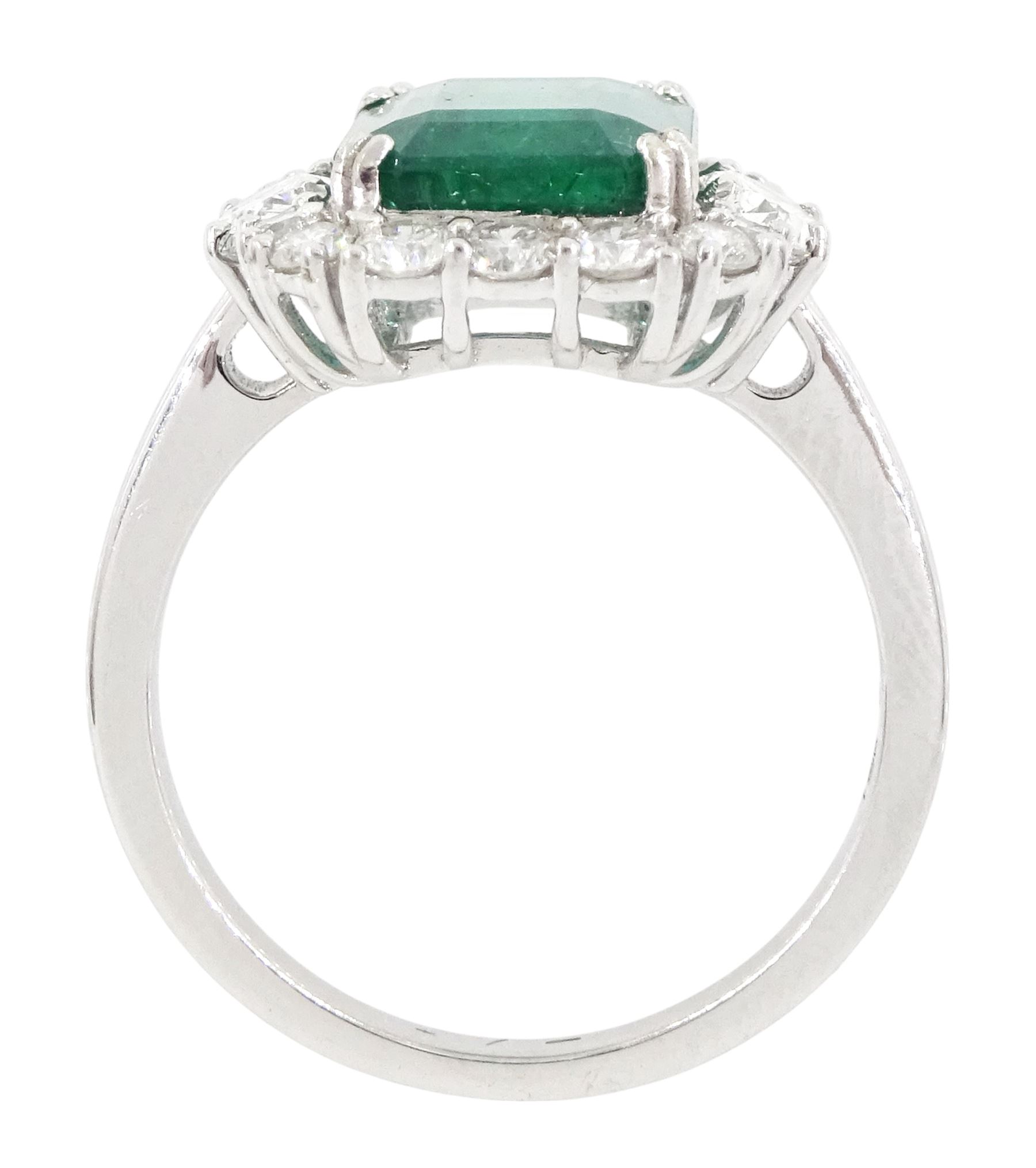 18ct white gold emerald and diamond cluster ring, the octagonal cut emerald of approx 2.85 carat, with an oval cut diamond set either side and round brilliant cut diamond surround, stamped, total diamond weight approx 1.05 carat
