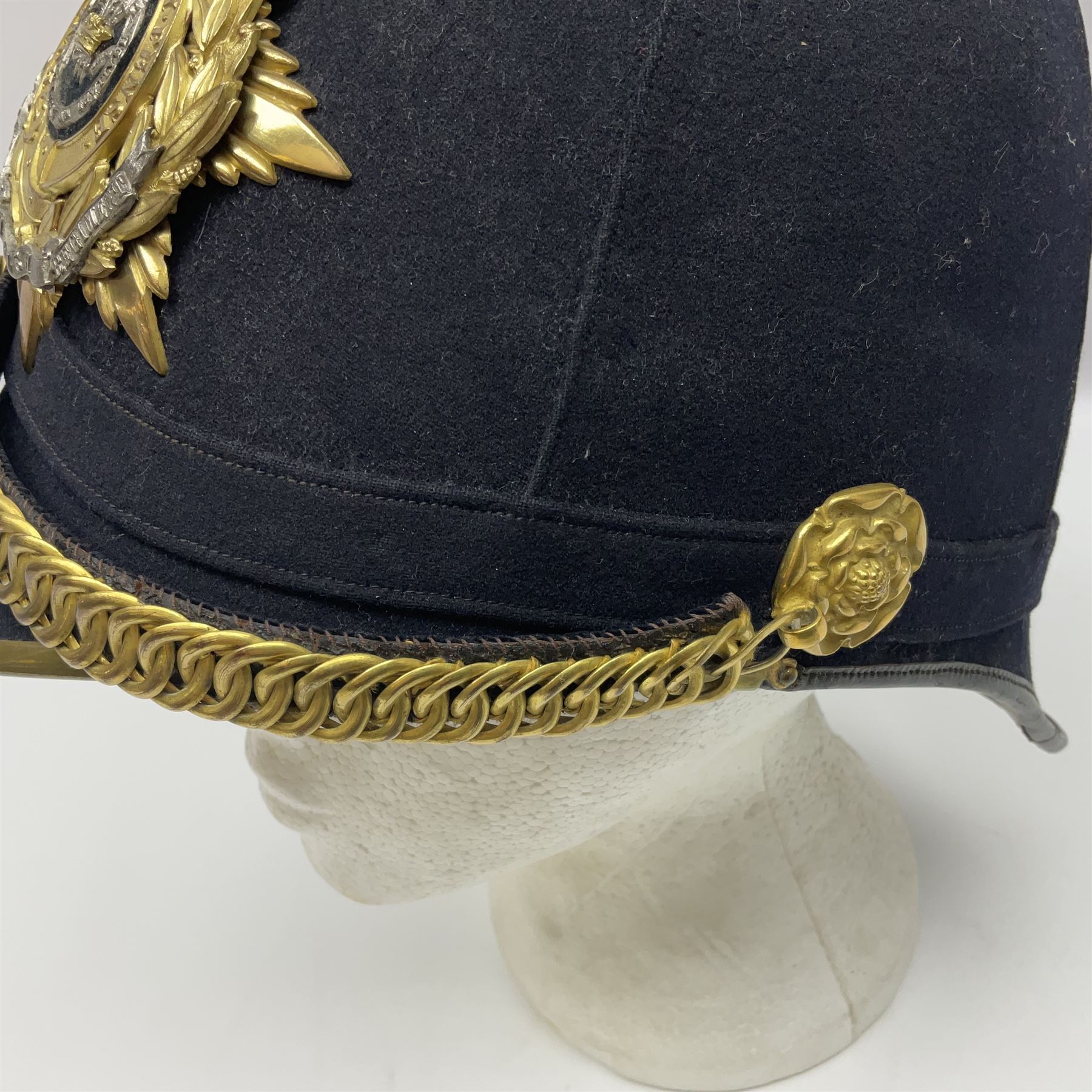 Post-1902 Welsh Regiment Officer's Home Service Blue Cloth Helmet with gilt metal King's crown helmet plate to the front, a removable spike to the top on a shaped cruciform base with rosette fittings, rosette side bosses, brass trim to the front peak, and leather and velvet backed chin scales, with sweat band, the interior with the remains of a makers label at the address 1,3 & 5 Lexington Street, Golden ? London W (presumably Hobson & Sons)