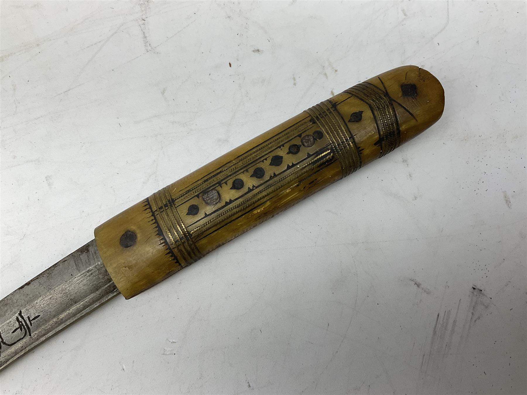 Near pair of African Moroccan Berber tribal Shula daggers each with engraved 39cm curving fullered steel blade, carved and inlaid horn grip and leather covered scabbard L57cm overall; kindjal style dagger with brass covered and jewelled grip and scabbard; another Eastern dagger with leather covered grip and scabbard; and a large Eastern knife with animal hide scabbard (5)