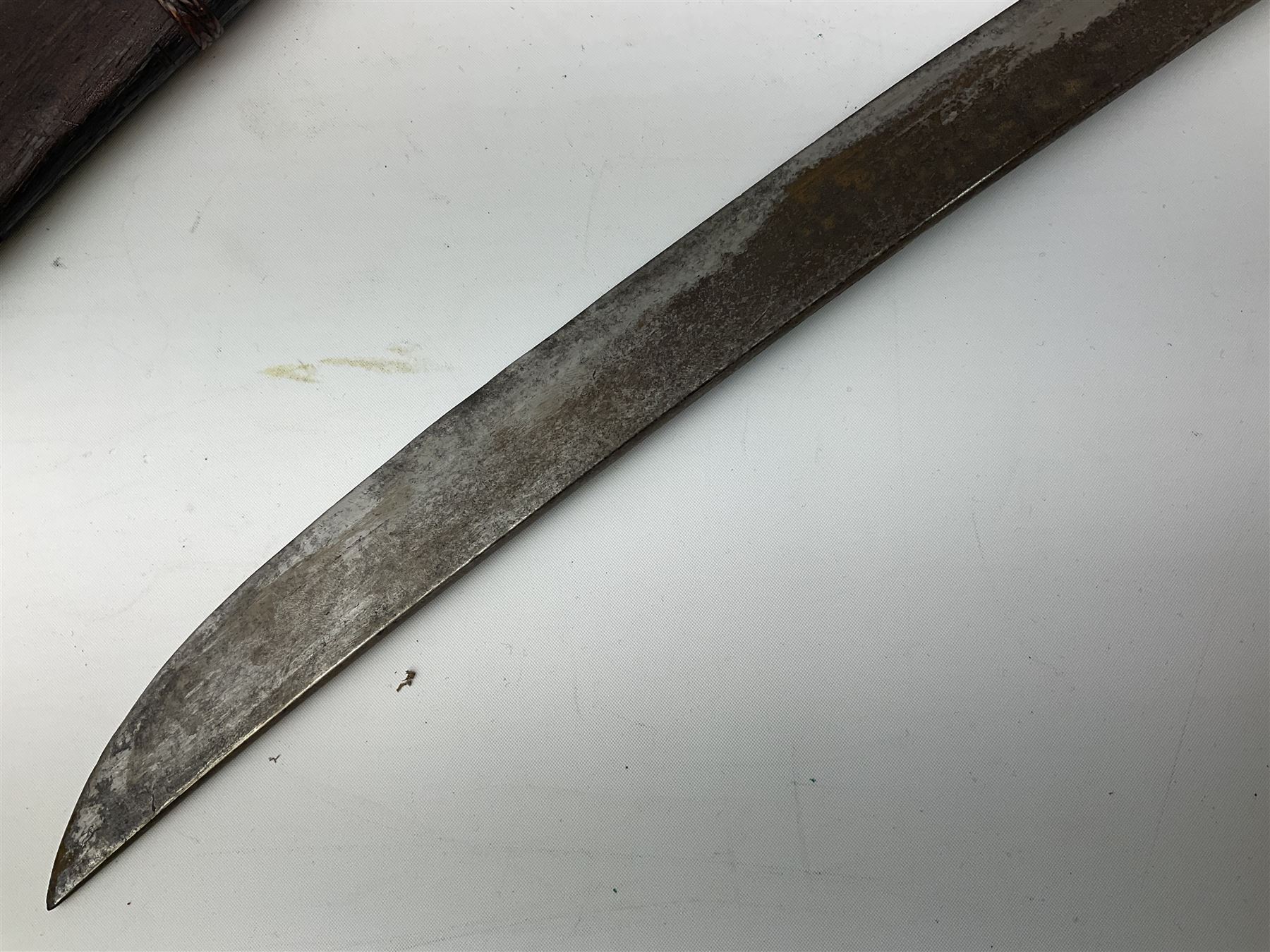 Burmese Dha type sword with 52cm plain steel slightly curving blade and plaited cane bound grip; in wooden scabbard with plaited cane bands L76.5cm overall