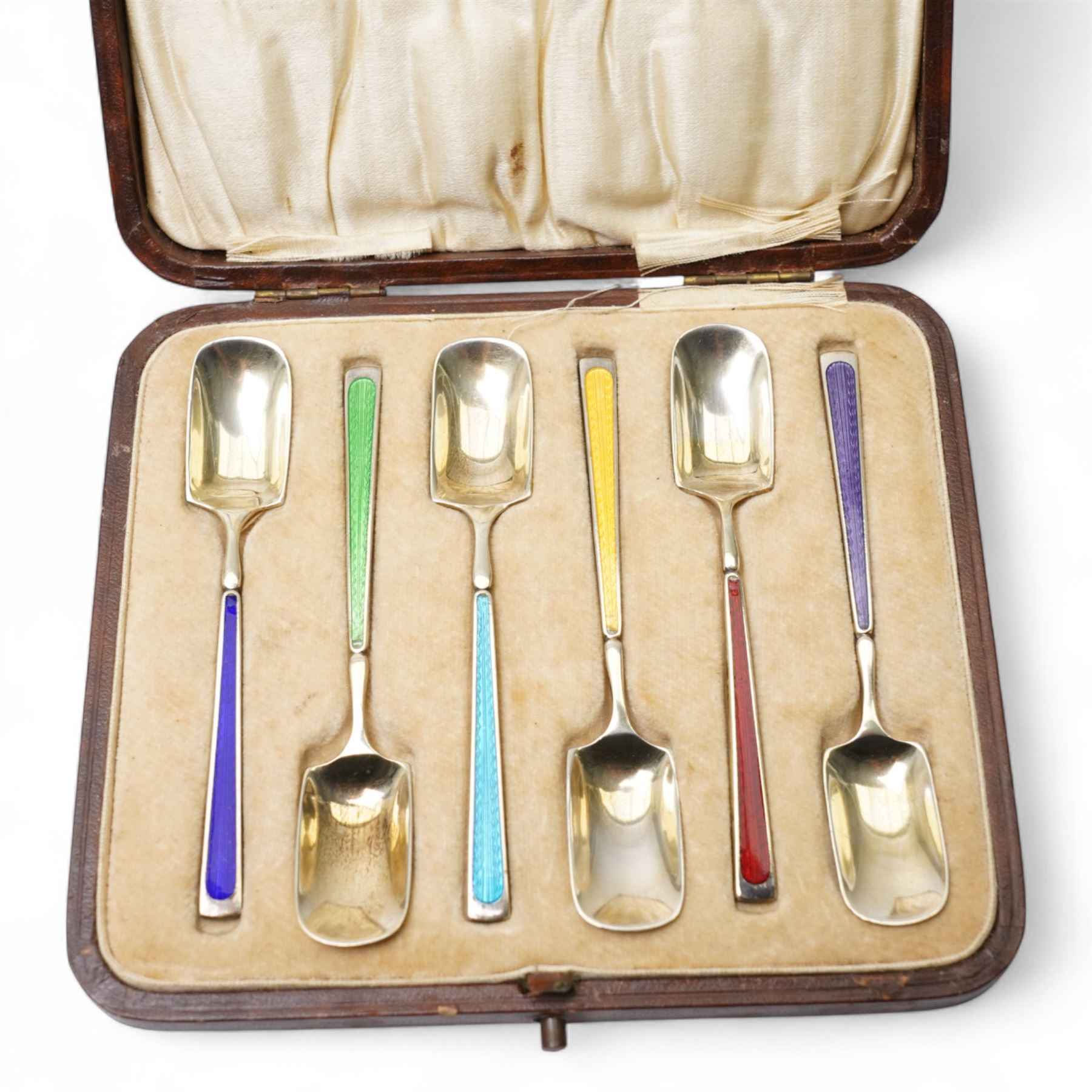 Set of six silver gilt coffee spoons with spade shape bowls, each stem with different coloured enamel and in original case Birmingham 1926/27 Maker Levi & Salaman