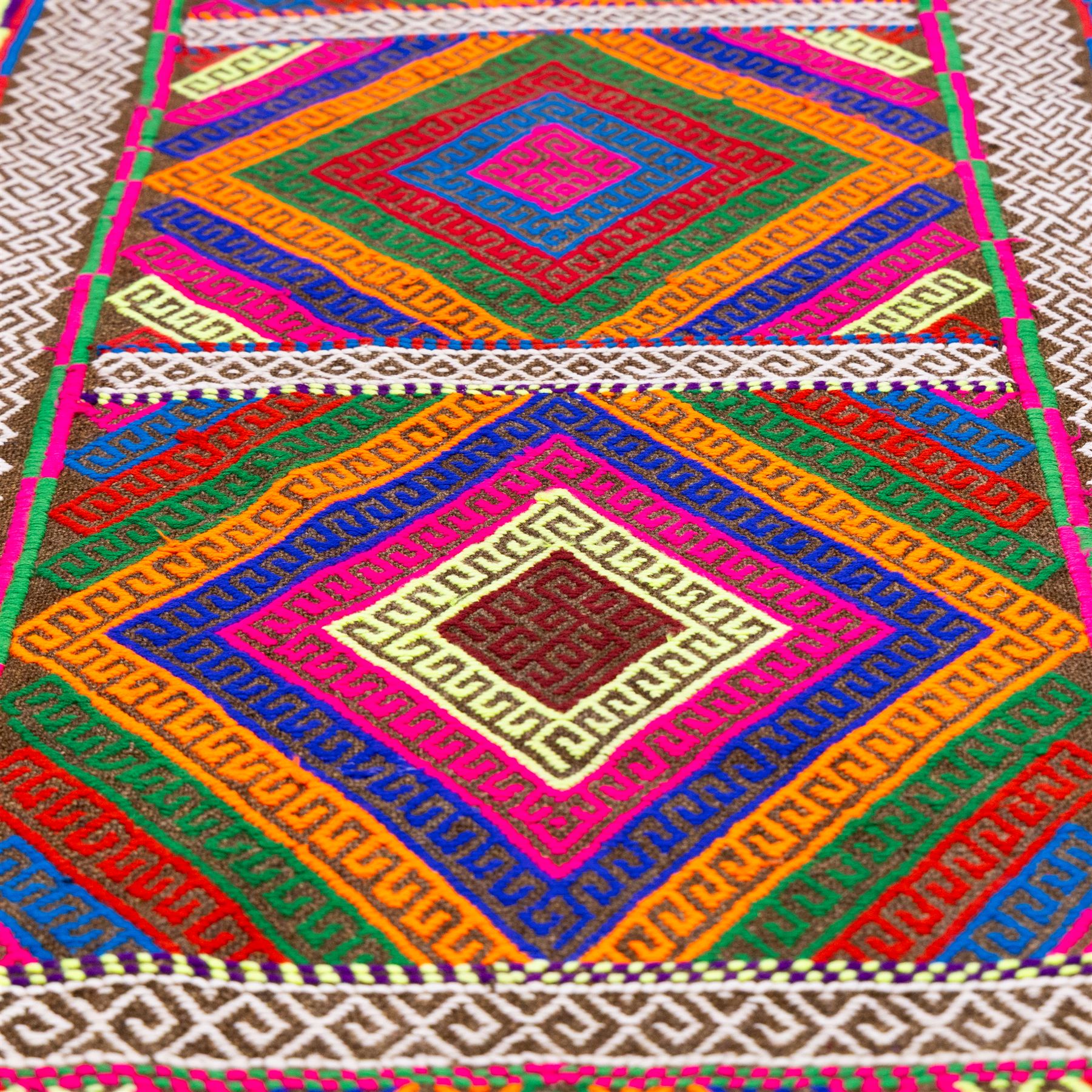 Afghan Suzni flatweave geometric design runner rug, decorated with trailing lozenges decorated with hooked motifs, within zig-zag bands, bright multi-coloured ground ivory and brown geometric main border