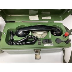 Three field telephones, with rotary dials, in hard plastic cases, one missing its cover, all with canvas straps, together with an extra handset. 
