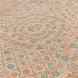 Aubusson design pale peach ground rug, woven with an all-over lattice design in rose and cyan with central floral bouquet medallion, the scrolling acanthi and flowerhead spandrels contained within a lattice guard band