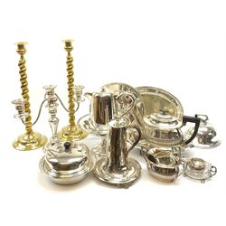A selection of assorted silver plate, to include teapot, twin handled open sucrier, and milk jug, each of part fluted form, muffin dish, candelabra with twin scroll branches, tea pot/hot water pot with two ivory insulator bands to the handle, pedestal bowl, etc., plus a pair of brass candlesticks with writhern twist stems. (Qty). 