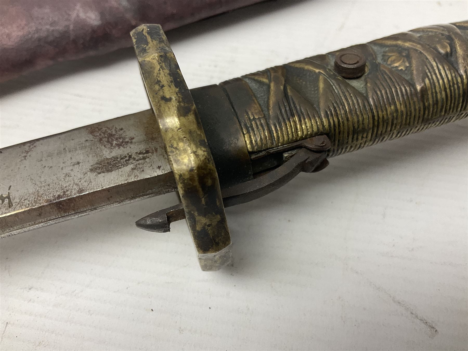 Copy of a WWII Japanese NCO sword, the 65cm slightly curving blade stamped with pseudo Japanese characters and cast brass simulated cord bound grip; in officer's leather bound field scabbard L97cm overall