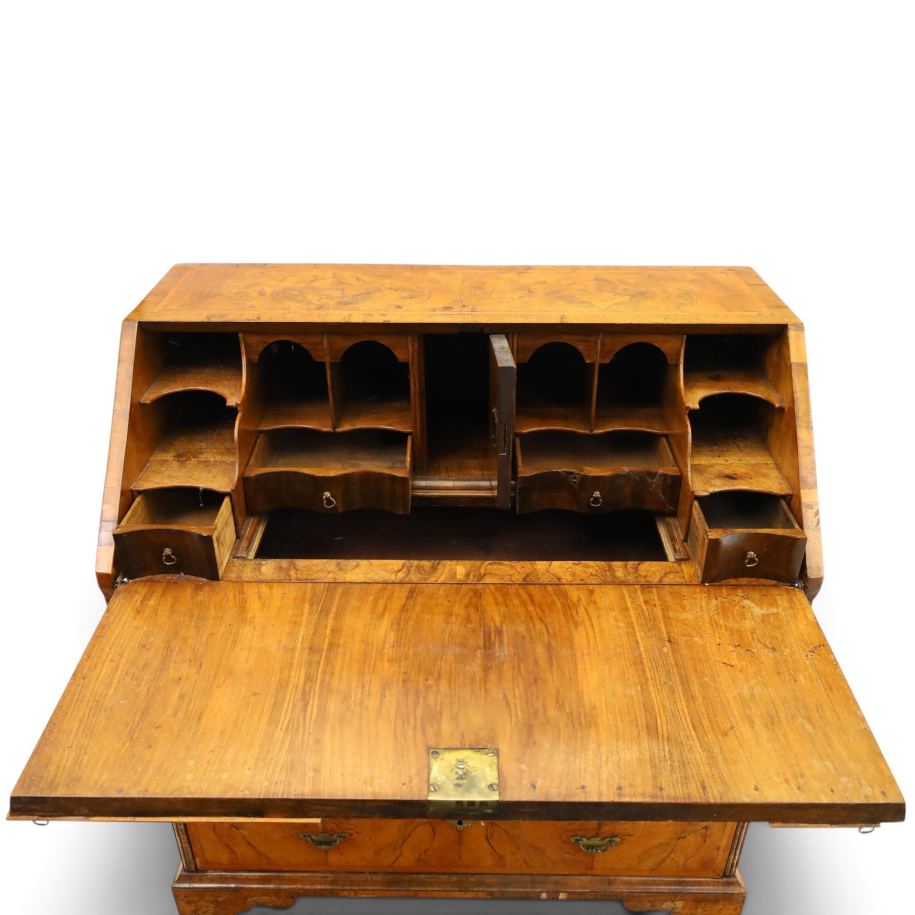 18th century figured walnut bureau, the sloped fall-front enclosing fitted interior with sliding base, pigeon-holes and correspondence drawers with shaped facias, over two short and two long feather-banded drawers with pressed brass handle plates, on bracket feet