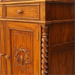 Victorian design rosewood side cabinet, the rectangular moulded top above four frieze drawers with turned wooden knob handles, over twin cupboard doors carved with foliate panels, flanked by barley twist uprights, upon turned bun feet