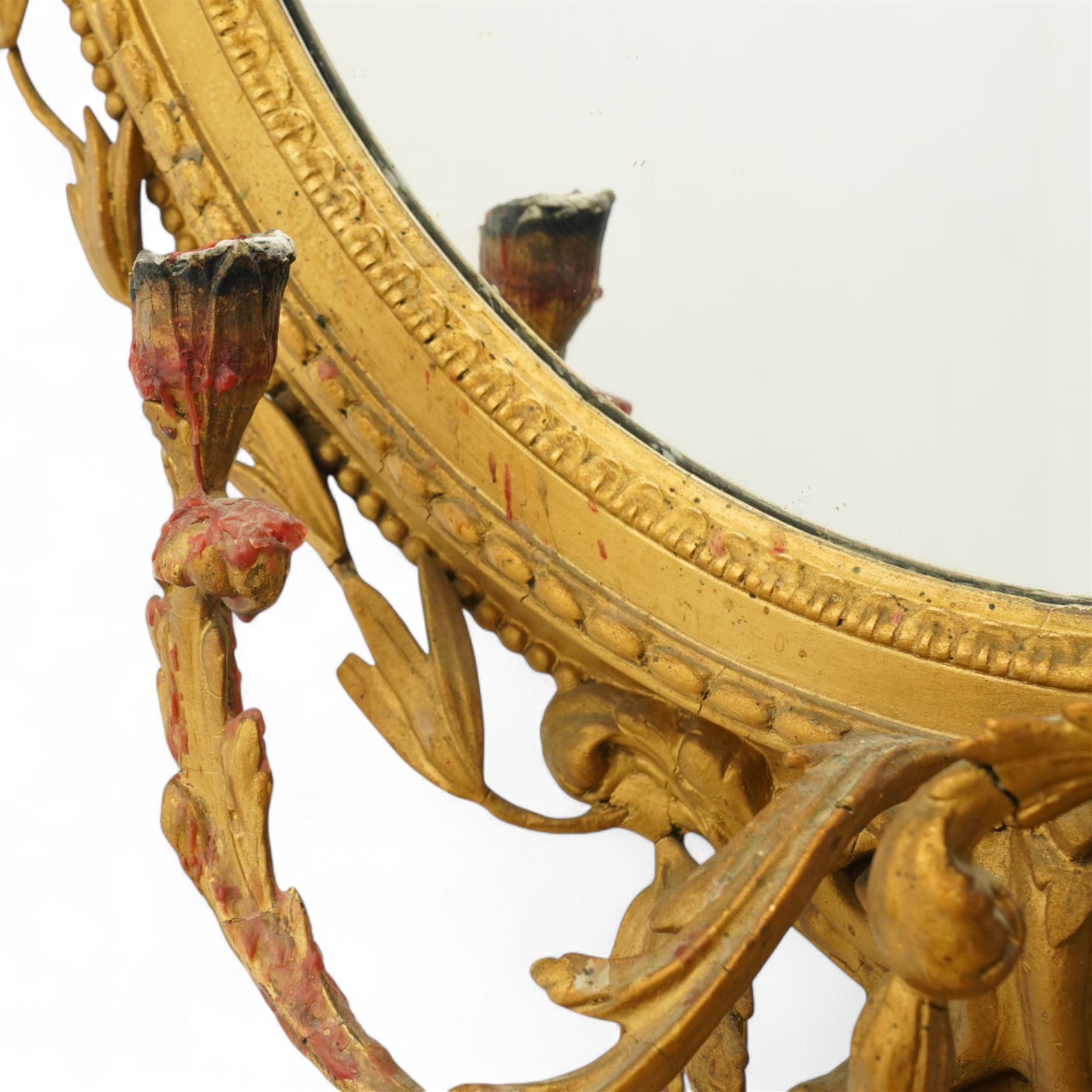Late 19th century Louis XVI style giltwood and gesso girandole oval wall mirror, the oval frame surmounted with stylized urn finial and ribbon-tied garlands, laurel swags and rosettes, egg and dart decorated inner moulding and linked acorn outer moulding, flanked by intertwined foliate decorated candle branches 