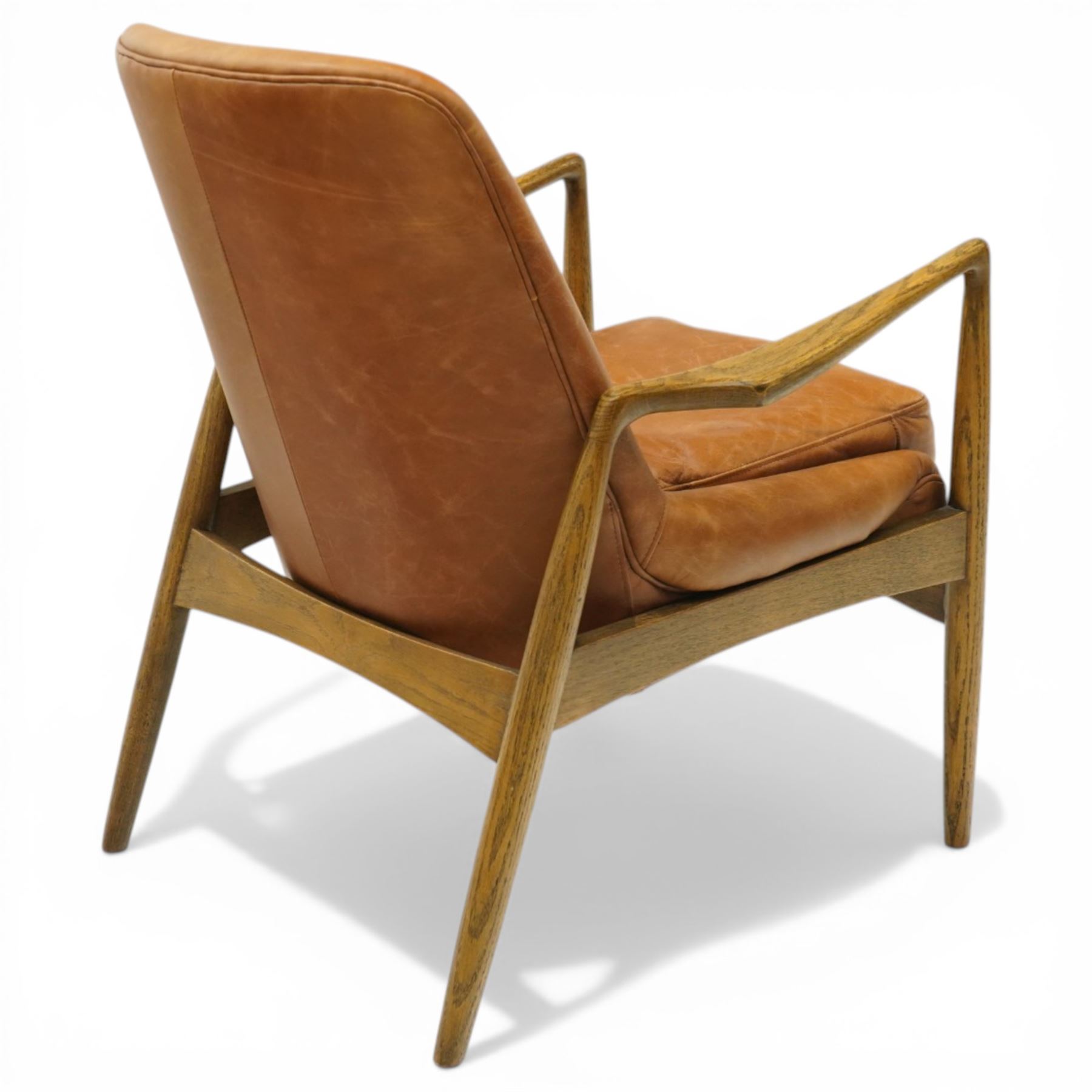 Mid-century design teak open easy armchair with brown leather upholstery, with shaped oak armrests and supports