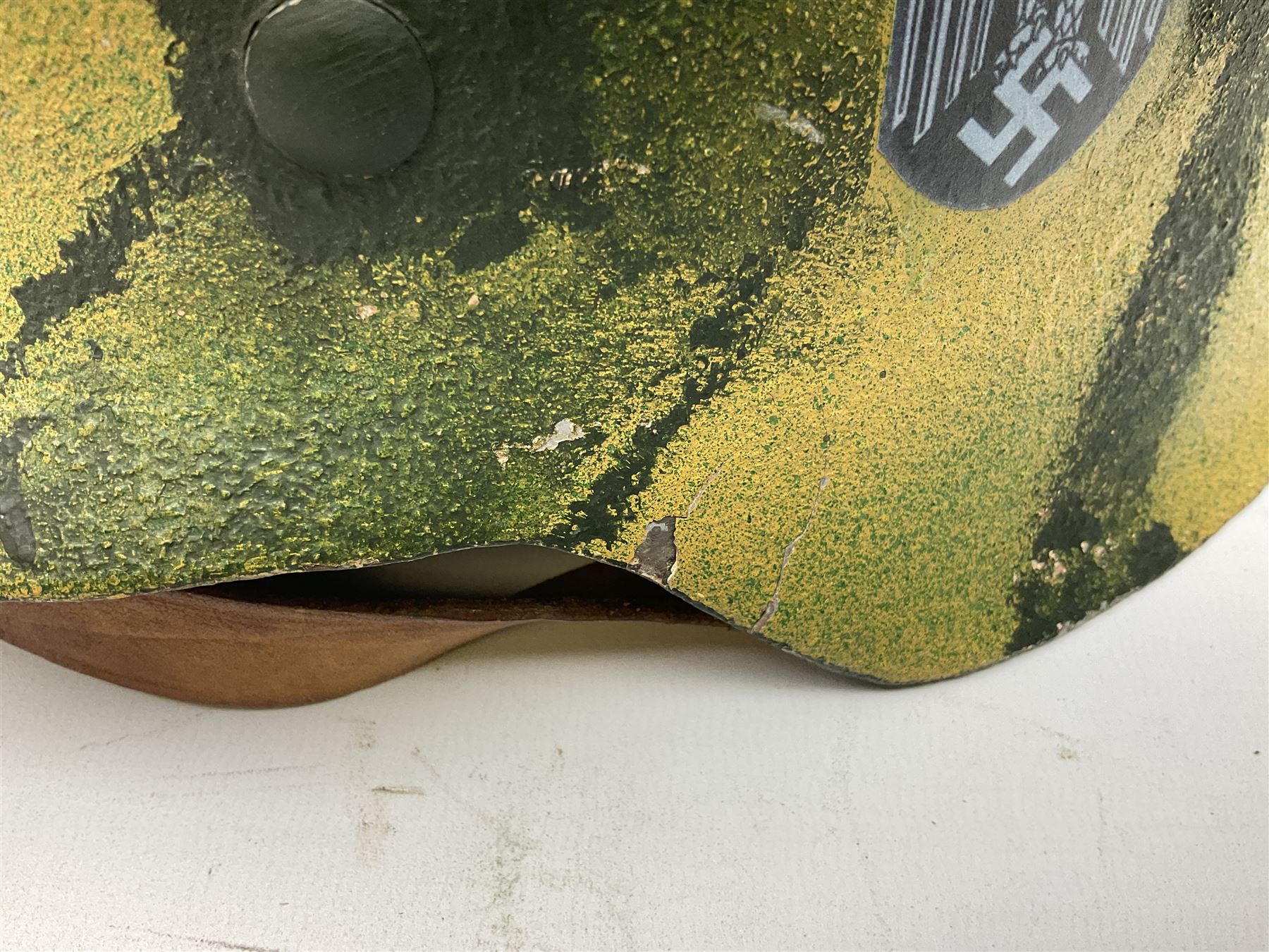 Fully restored German steel helmet, the camouflage painted exterior with two decals and replacement leather liner