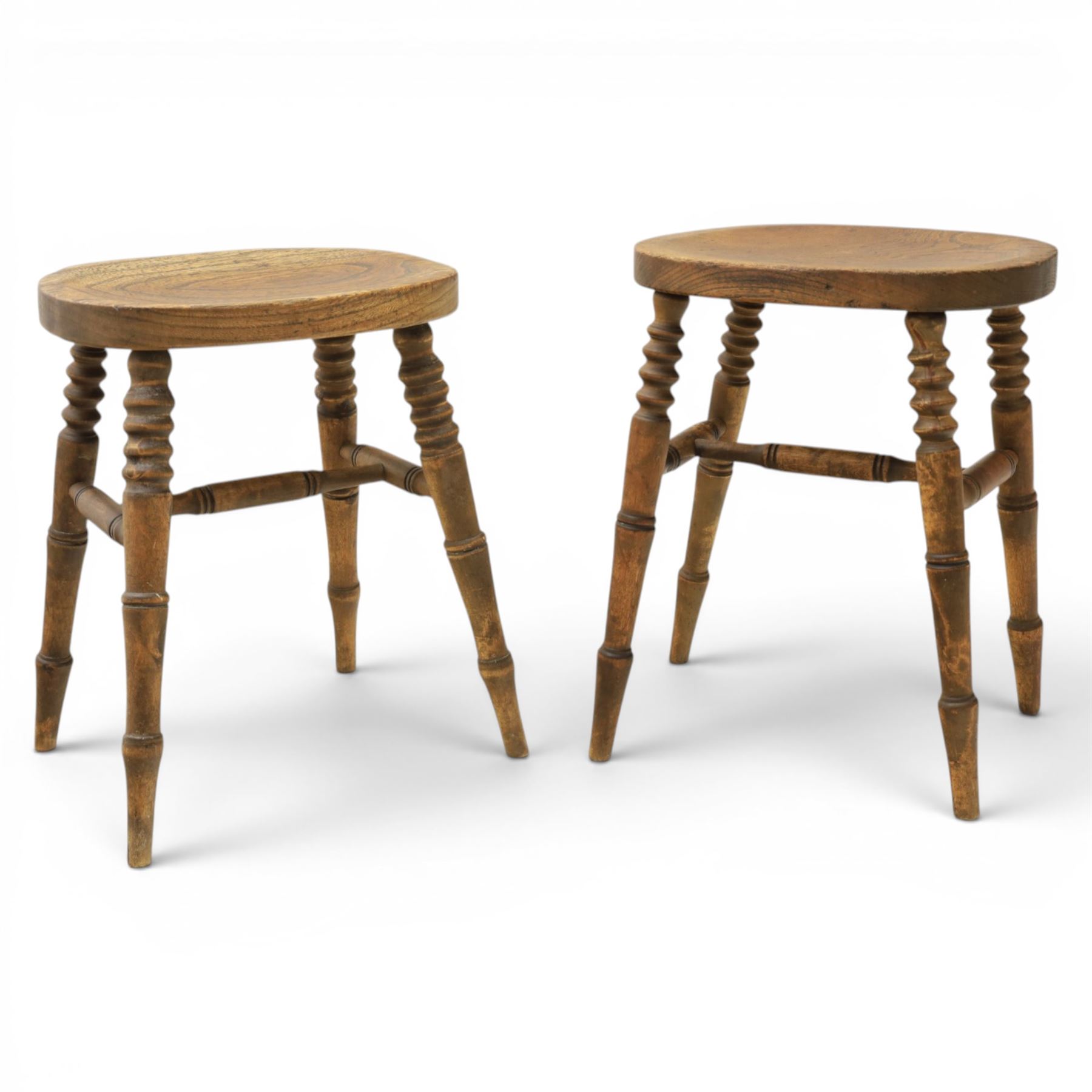 Pair of country elm stools, with oval dished seat raised on turned wooden supports, united by a H-stretcher