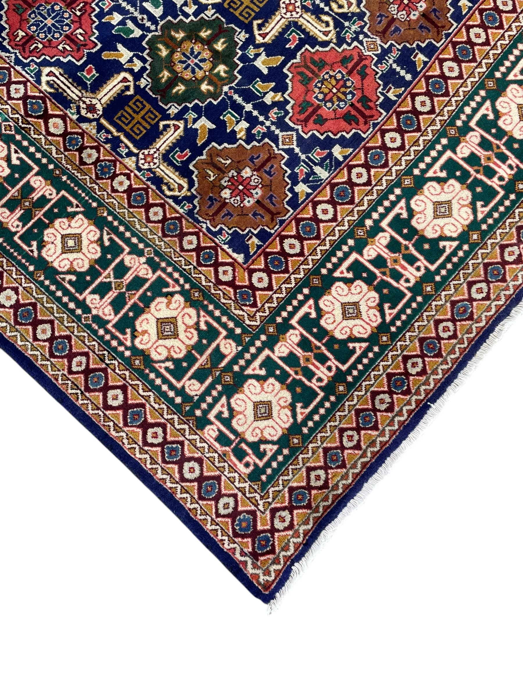 Persian Tabriz indigo ground rug, overall Quba design, decorated with repeating stylised plant motifs and interlaced with trailing leaf motifs, repeating border within geometric guard stripes