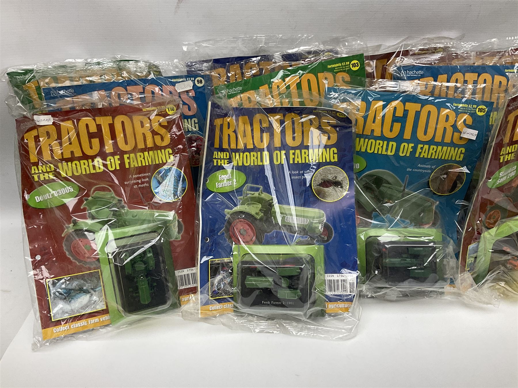 Eighteen issues of Tractors and The World of Farming magazine, together with sixty diecast tractors, all in original packaging, in three boxes 