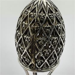 Modern silver limited edition Easter egg, no. 70/500, the openwork lattice body decorated with gilded panels of flower heads, opening to reveal a gilt interior, upon silver stand with three scrolling pad feet, each hallmarked St James House Company, London 1979, height including stand 8cm