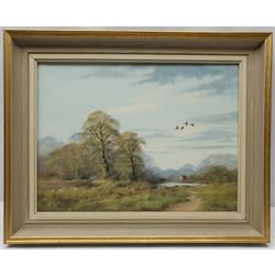 John Caesar Smith (British 1930-): Wooded Landscape with Geese in Flight, oil on canvas signed 29cm x 39cm