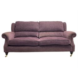 Parker Knoll - pair of large two-seat sofas upholstered in purple fabric, turned mahogany finish front feet with brass cups and castors 