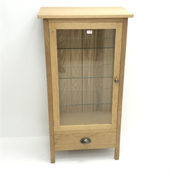  Light oak display cabinet, single door enclosing three glazed shelves, single drawer, stile supports, W68cm, H128cm, D39cm  
