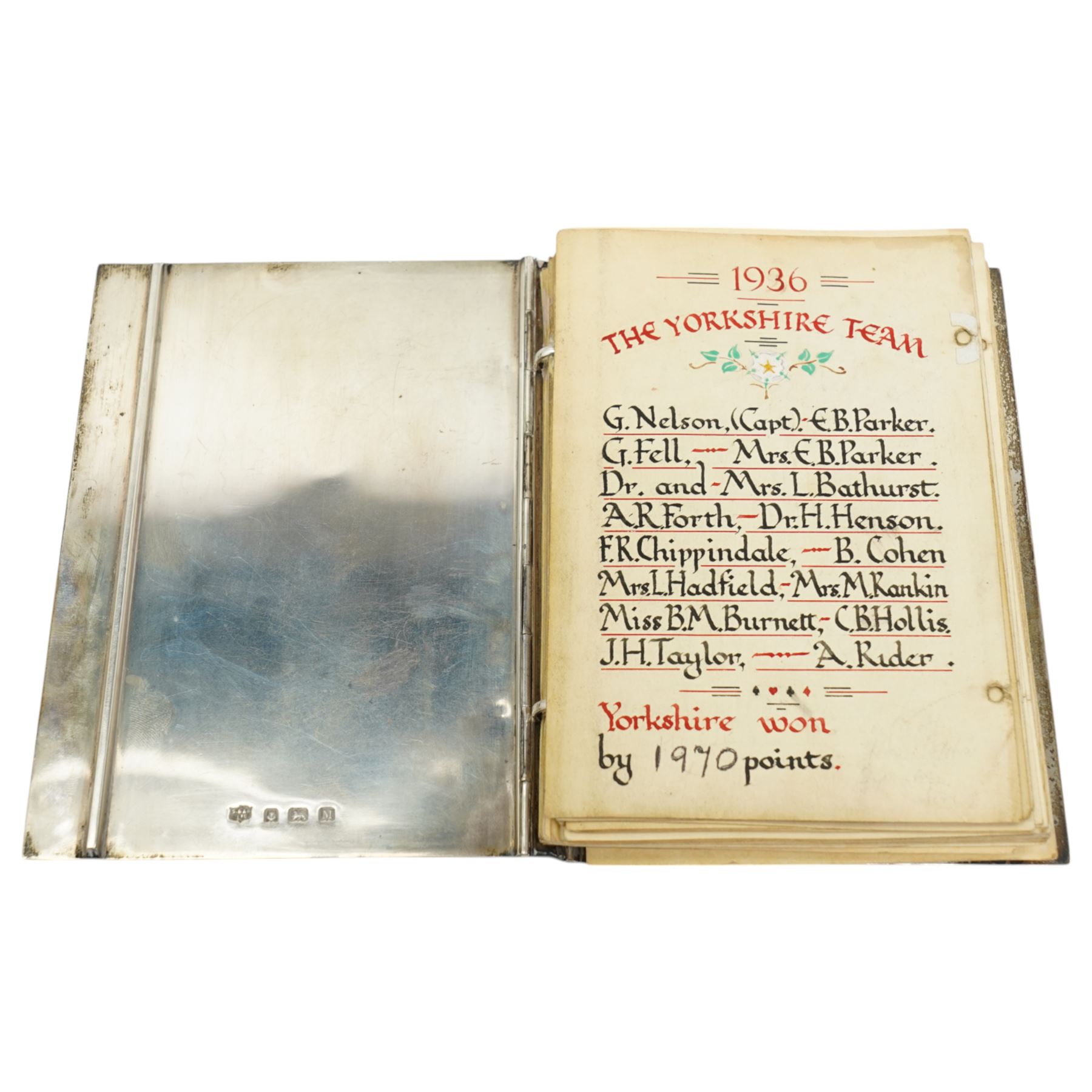 'The Roses County Contract Bridge Match, Yorkshire V Lancashire presented by Capt. G Fell 1936 for a record of the teams' - A silver booklet decorated with enamel roses containing hand drawn lists of the teams 1936 together with other team lists 1955-1984 15cm x 10cm Birmingham 1936 Maker S Blackensee & Son Ltd