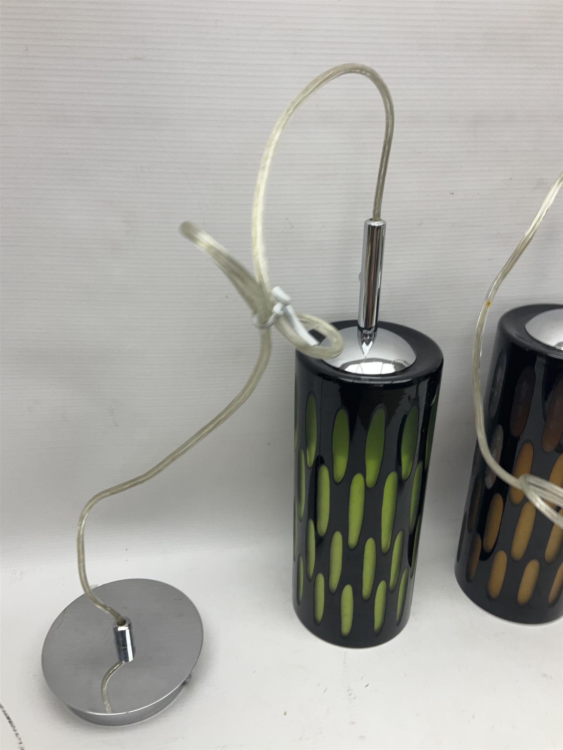 Three contemporary glass pendant lights, the black glass glass cut away revealing green and brown beneath, H24cm