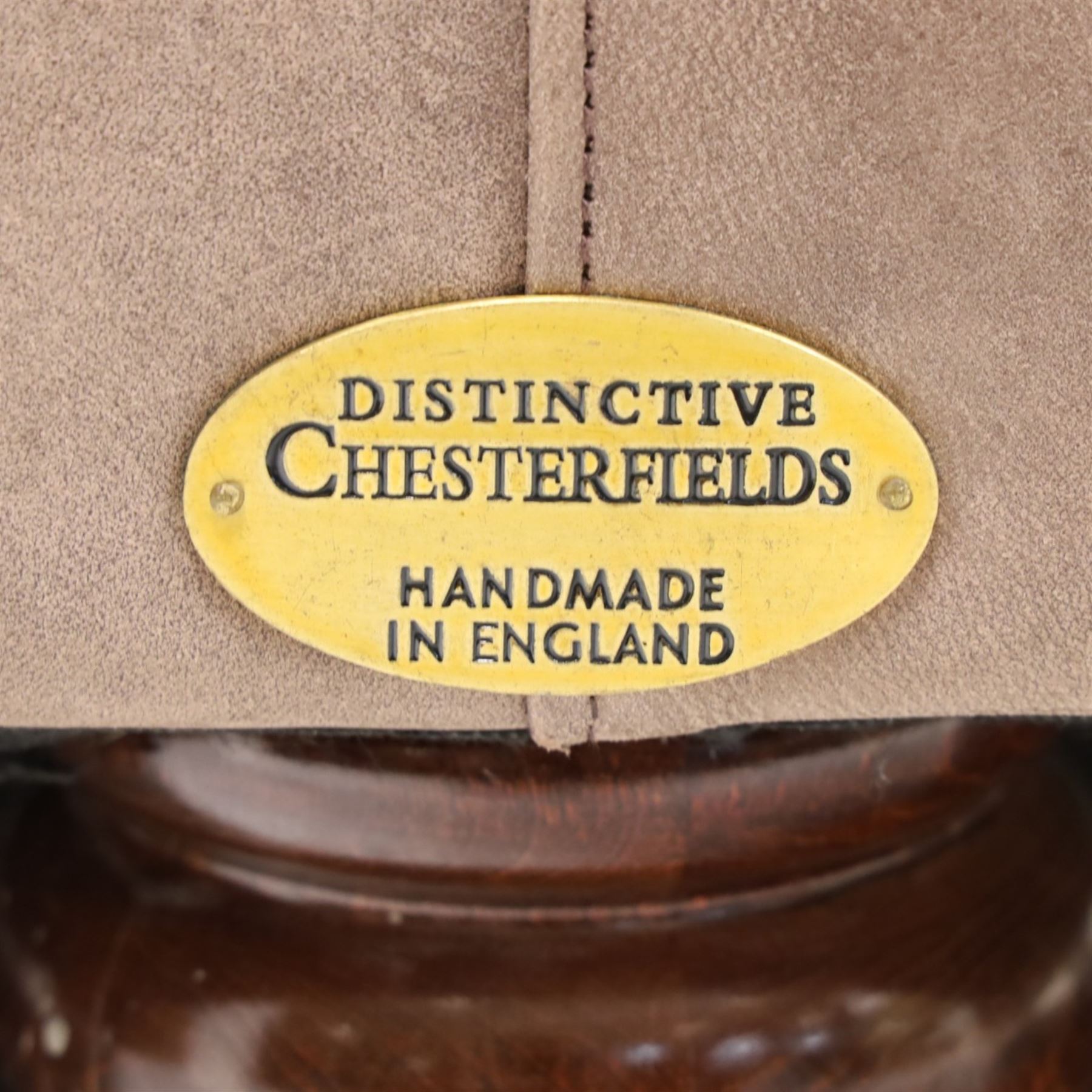 Distinctive Chesterfield - Chesterfield upholstered in taupe leather, deep button back and arms, loose seat cushions, raised on dark stained supports 