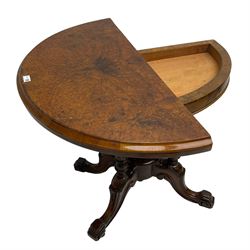 Victorian figured walnut demi-dune card table, the fold-over moulded top with circular baize lining, on four turned pillars with central finial platform, four splayed moulded supports with angular scrolled feet, on castors