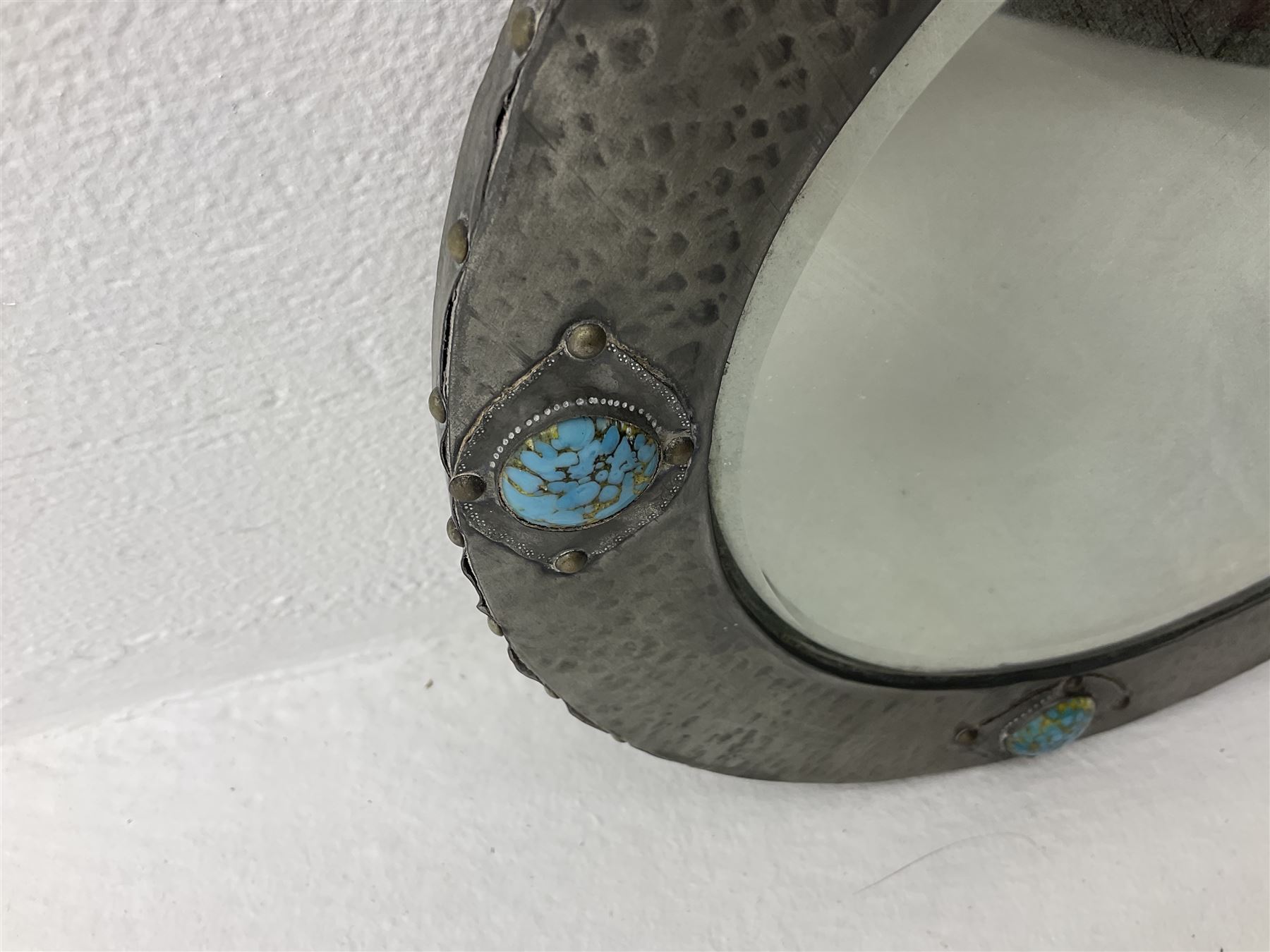 Arts & Crafts style circular hammered pewter mirror inset with four turquoise cabochons, D27.5cm