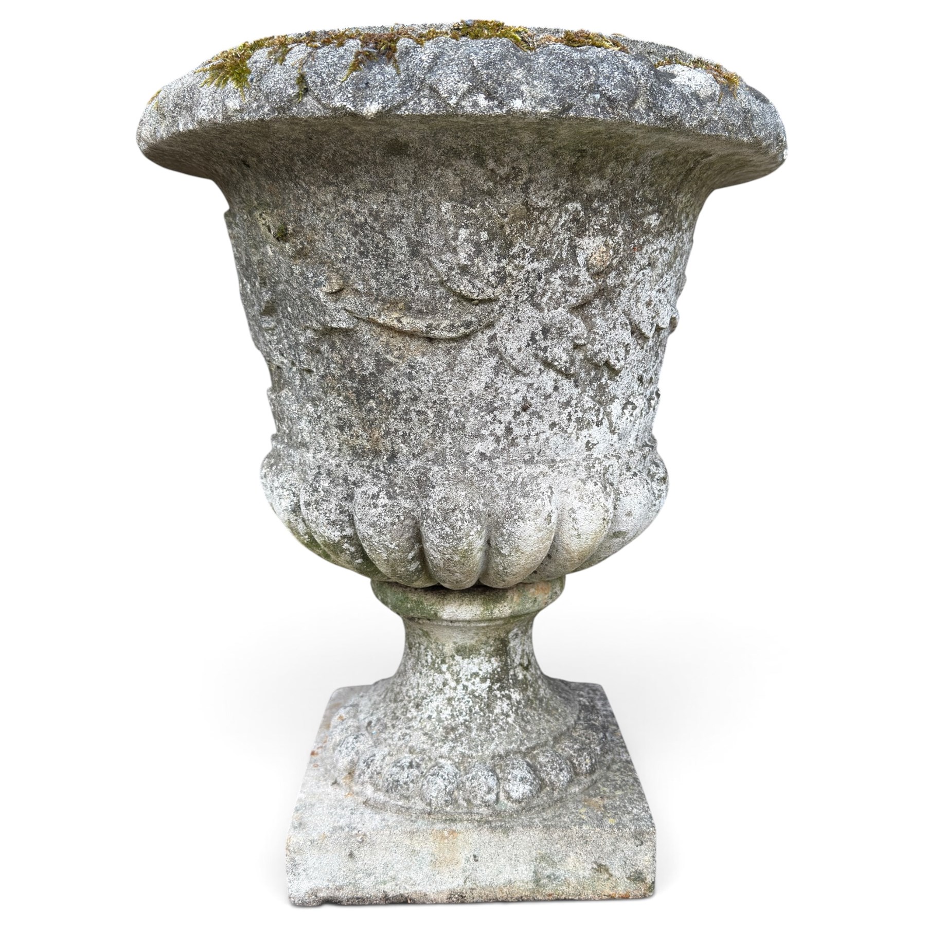 Set of four weathered composite stone urns of campana form, the everted leaf-moulded rolled rim over a body decorated with scrolling fruiting grapevines in relief, over a gadrooned underbelly and waisted socle, lobed collar on square base