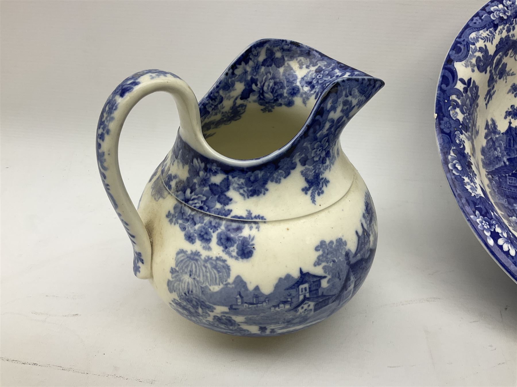 Mintons Genevese pattern wash bowl, jug and toothbrush holder, together with a similar Mintons blue and white soap dish, all decorated in the oriental style, all with printed marks beneath, largest D32cm