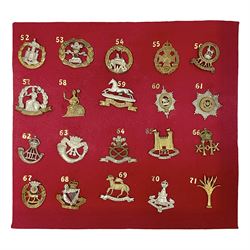 Twenty cap badges including Welsh Guards, Kings Royal Irish Hussars, York & Lancaster,  Loyal Suffolk Hussars, North Stafford, Durham Light Infantry, Cheshire, West Yorkshire, Norfolk, South Wales Borderers, Dorsetshire etc; mounted on a board for display