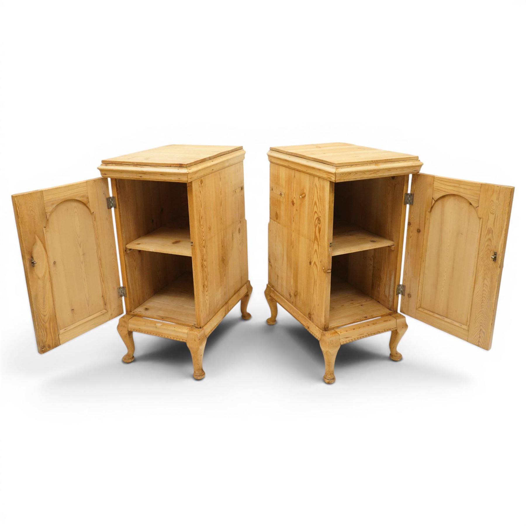 Pair of early 20th century pitch pine bedside cabinets, door with applied foliate carving, raised on cabriole legs