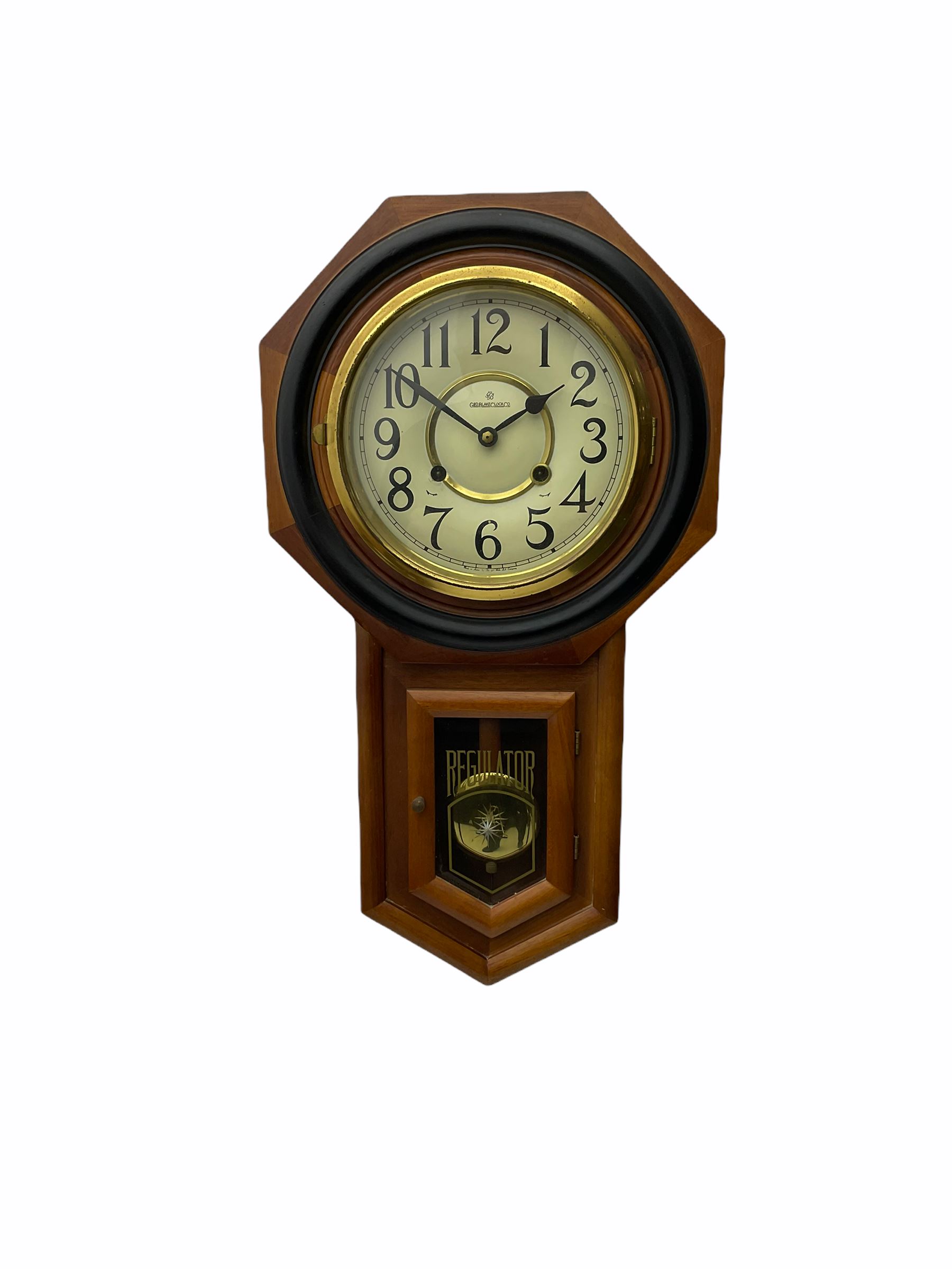 Contemporary spring driven wall clock striking the hours on a gong, case with a wooden octagonal dial surround and two piece creme dial with Arabic numerals, steel spade hands, brass effect pendulum bob visible through case door, dial inscribed 