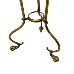 Edwardian oak and brass revolving magazine stand, arched frame with slatted slides and oak base, mounted on a brass column supported by three stylized scrolling legs terminating in pad feet