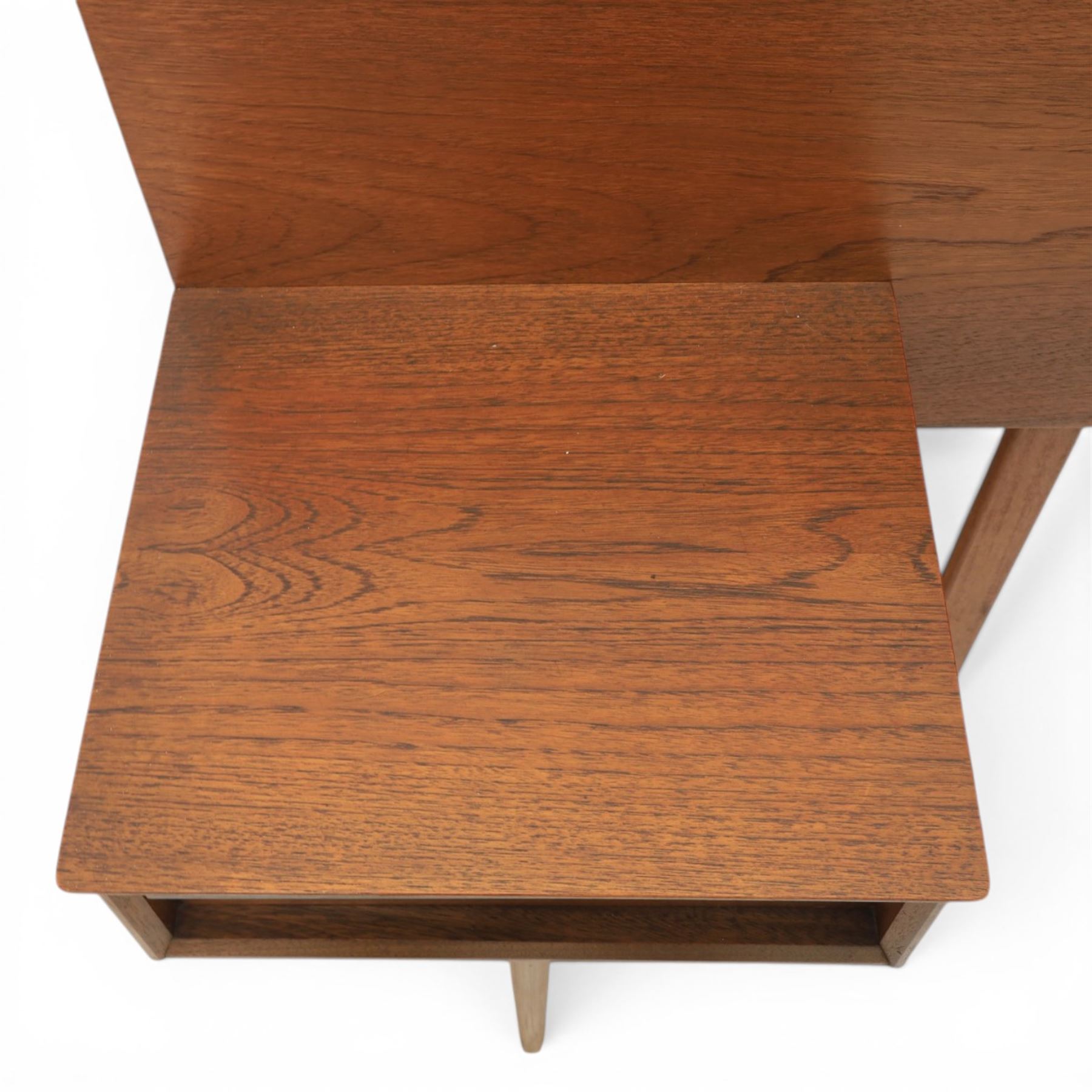 Austinsuite - mid 20th century teak headboard with bedside cabinets and matching  mirrored dressing table, the headboard with floating single drawer bedsides raised on a single tapering support, the dressing table with attached tilting mirror, above rectangular top with kneehole and two banks of two drawers, raised on tapering supports

Headboard H 84cm, D 40cm, W 229cm, W between bedsides 151cm 
Dressing table H 113cm D 44cm, W 149cm, H to underside of dresser 61cm