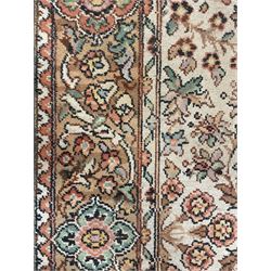 Large Persian design carpet, overall floral design, the field decorated with large rosette motifs surrounded by trailing foliate motifs, the border decorated with trailing branch and stylised plant motifs