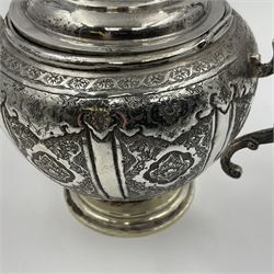 Early/mid 20th century Persian silver tea service, comprising circular serving tray, teapot, twin handled sucrier and cover, milk jug, five tea glasses with six silver holders, six tea spoons, and pair of sugar tongs, each profusely chased with foliate arabesque decoration, each bearing marks including 84 for 840 fineness, tray D40cm, teapot H16cm