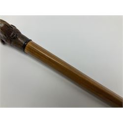 20th century walking cane, the carved wooden handle modelled as the head of a dog with inset glass eyes and articulated and sprung jaw, upon a tapering Malacca shaft, L93cm
