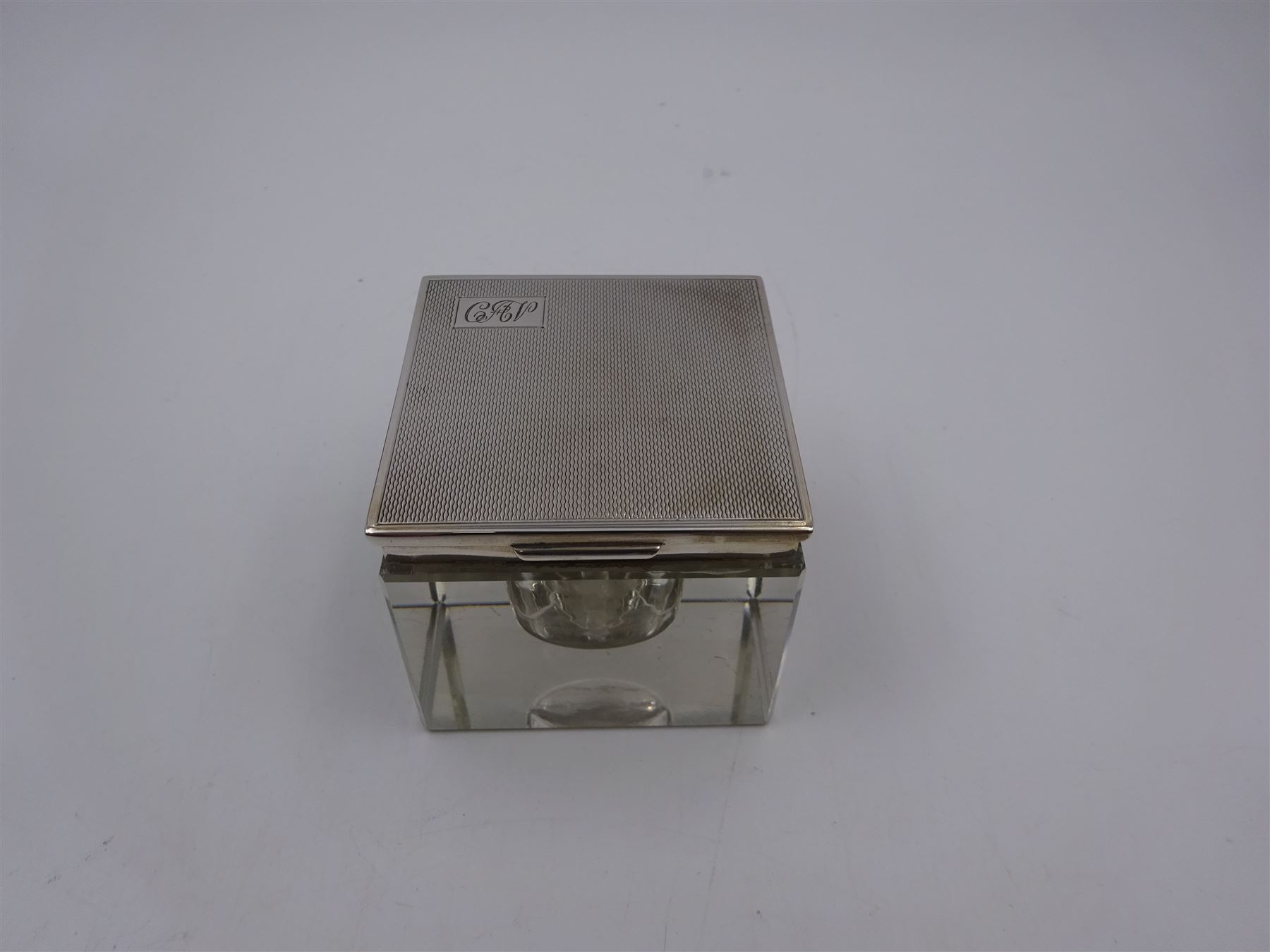 1930s silver mounted glass inkwell, of square form, the silver lid with engine turned decoration and engraved initials, hallmarked Adie Brothers Ltd, Birmingham 1937, H4.7cm
