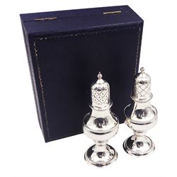 Modern silver two piece cruet set, comprising salt shaker and pepper shaker, both of waisted form with engraved rope twist borders, the removable pierced covers each with engraved lattice decoration, upon a circular spreading foot, hallmarked Laurence R Watson & Co, Birmingham 1989, H14.5cm, contained within velvet lined fitted case