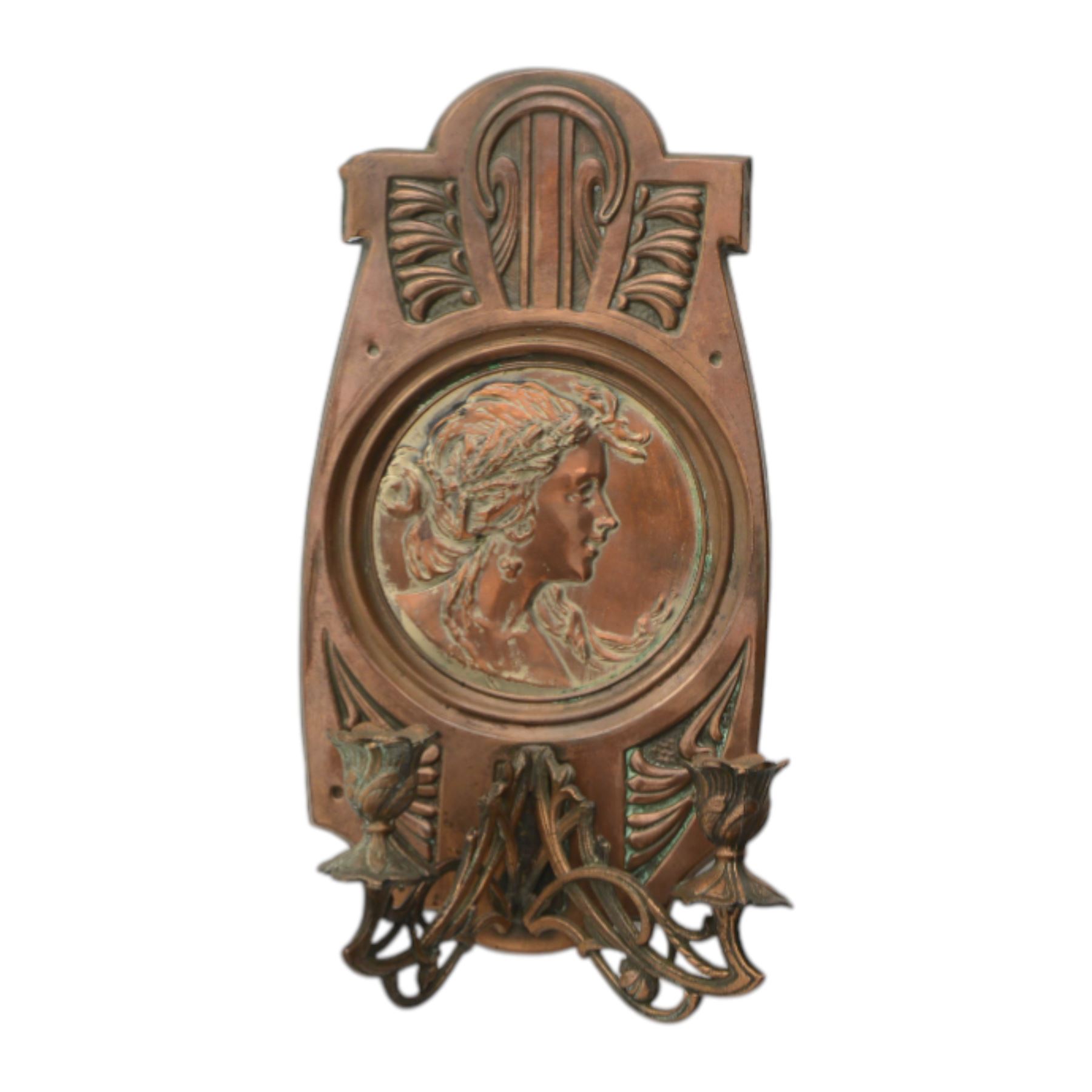 Pair of late 19th/early 20th century Art Nouveau copper twin branch wall sconces, each with shaped back plate chased with a central panel of a maiden in profile above and surmounted by foliate motifs, supporting two foliate open cast branches with bud sockets above conforming drip pans, H31cm W16cm D8.5cm
